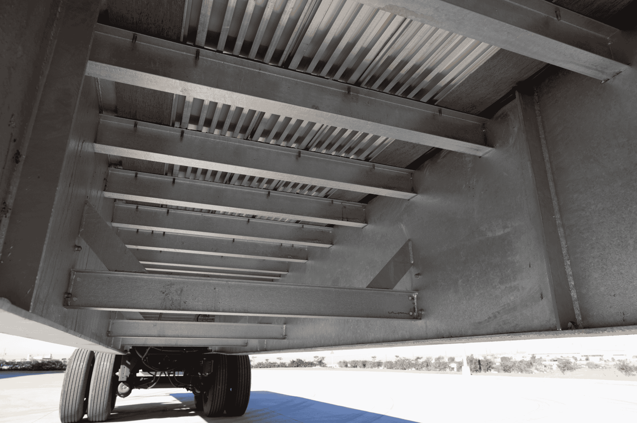 Underside view of a Hyundai Translead Latitude Flatbed trailer, revealing its robust subframe and structural components, demonstrating Hyundai Translead's advanced trailer technology and durability.